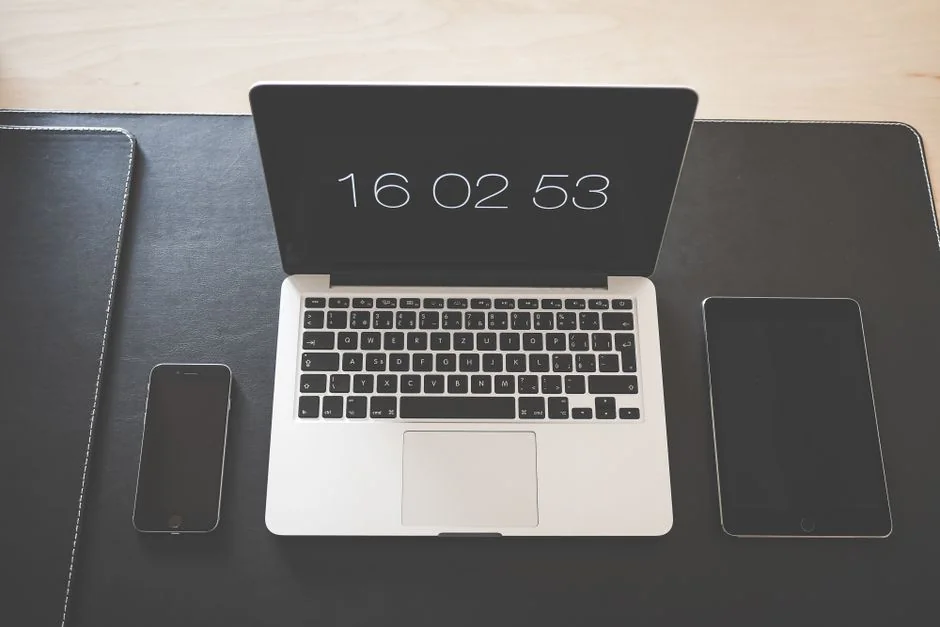 Gros plan sur un smartphone affichant une image floue, posé sur un bureau à côté d’un ordinateur portable.